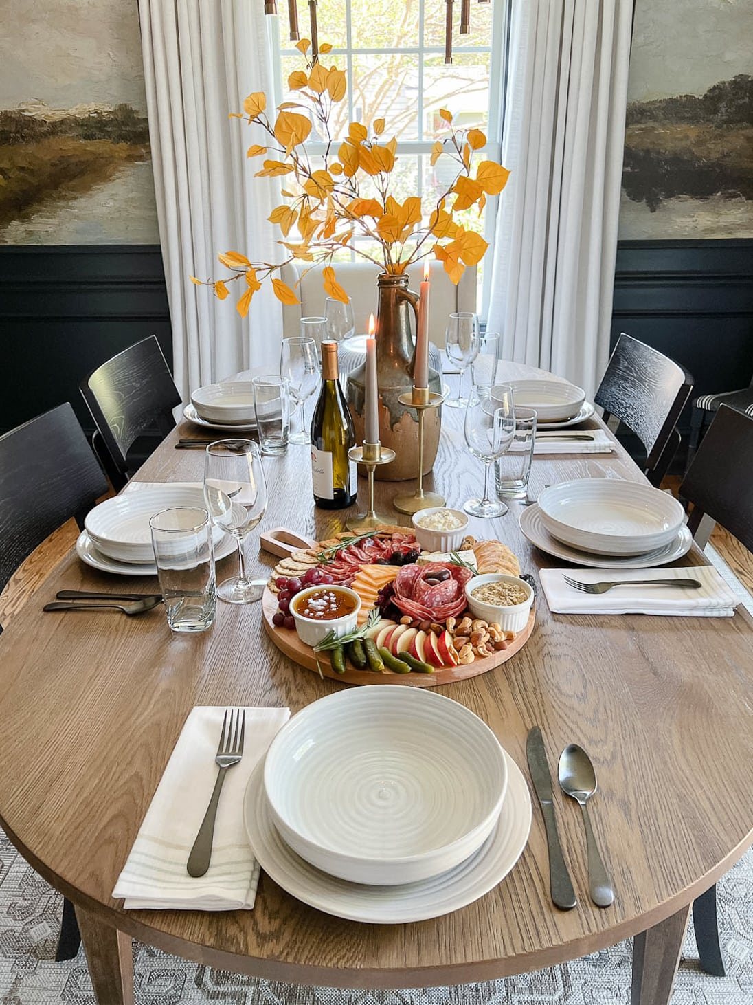 set dinner table with fall leaves in a vase and candles