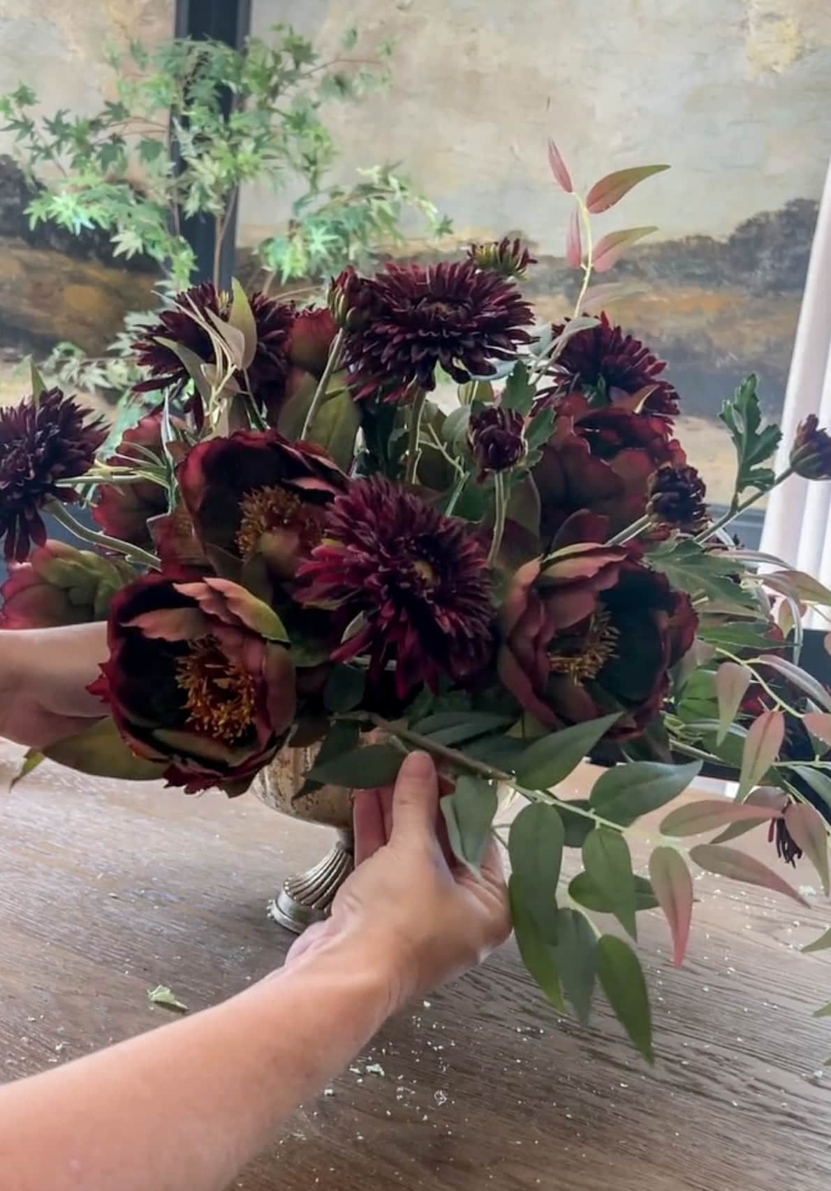 adding leafy stems into a flower arrangement