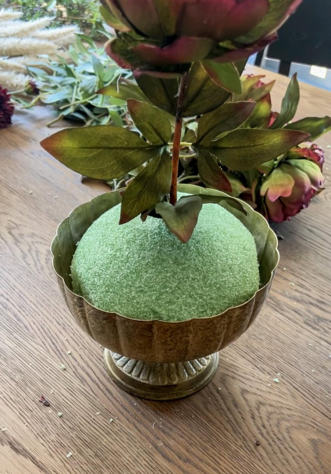 starting a floral arrangement with focal flower stem in top