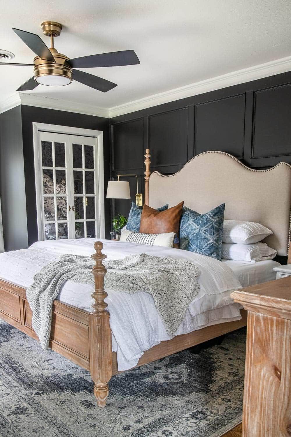 black bedroom with king sized bed, white mirrored closet doors, and white bedding