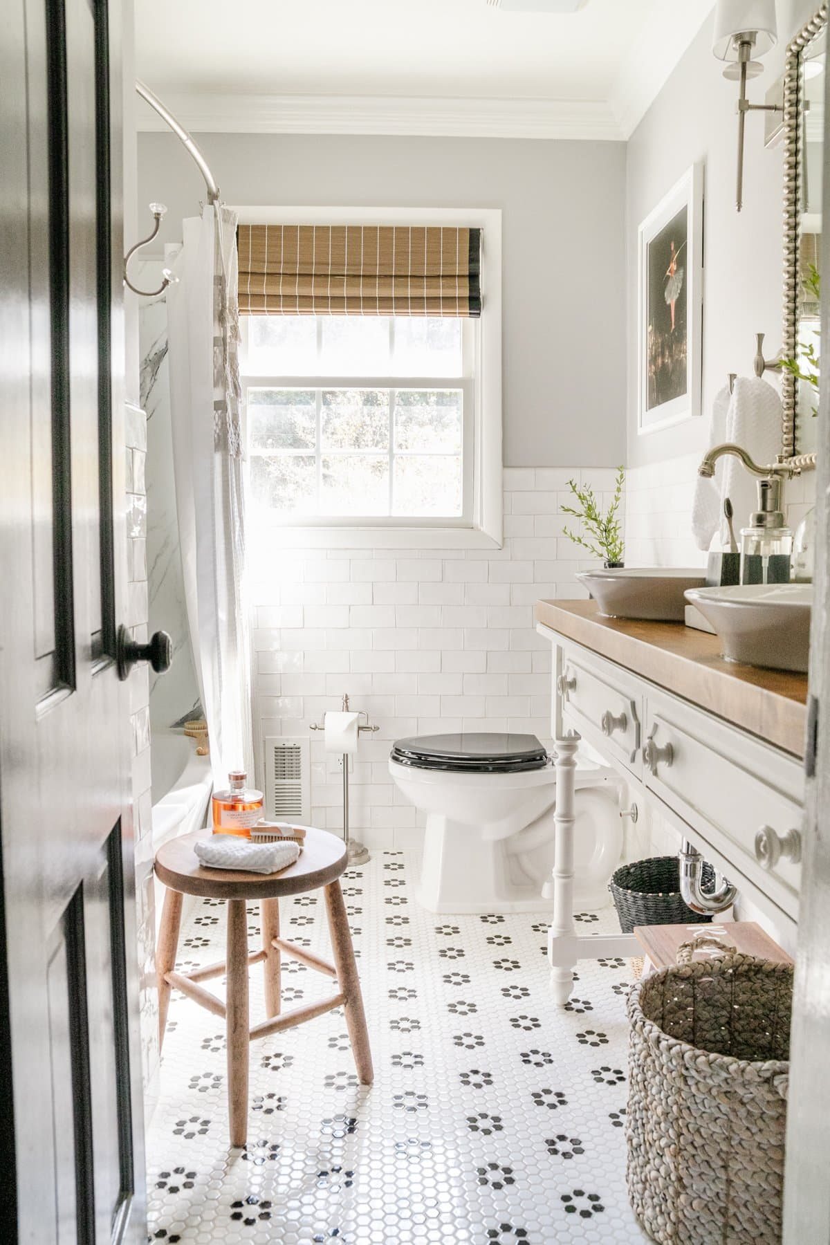 gray, black and white bathroom with console table converted into a bathroom vanity, subway tile walls, and black and white retro tile floor