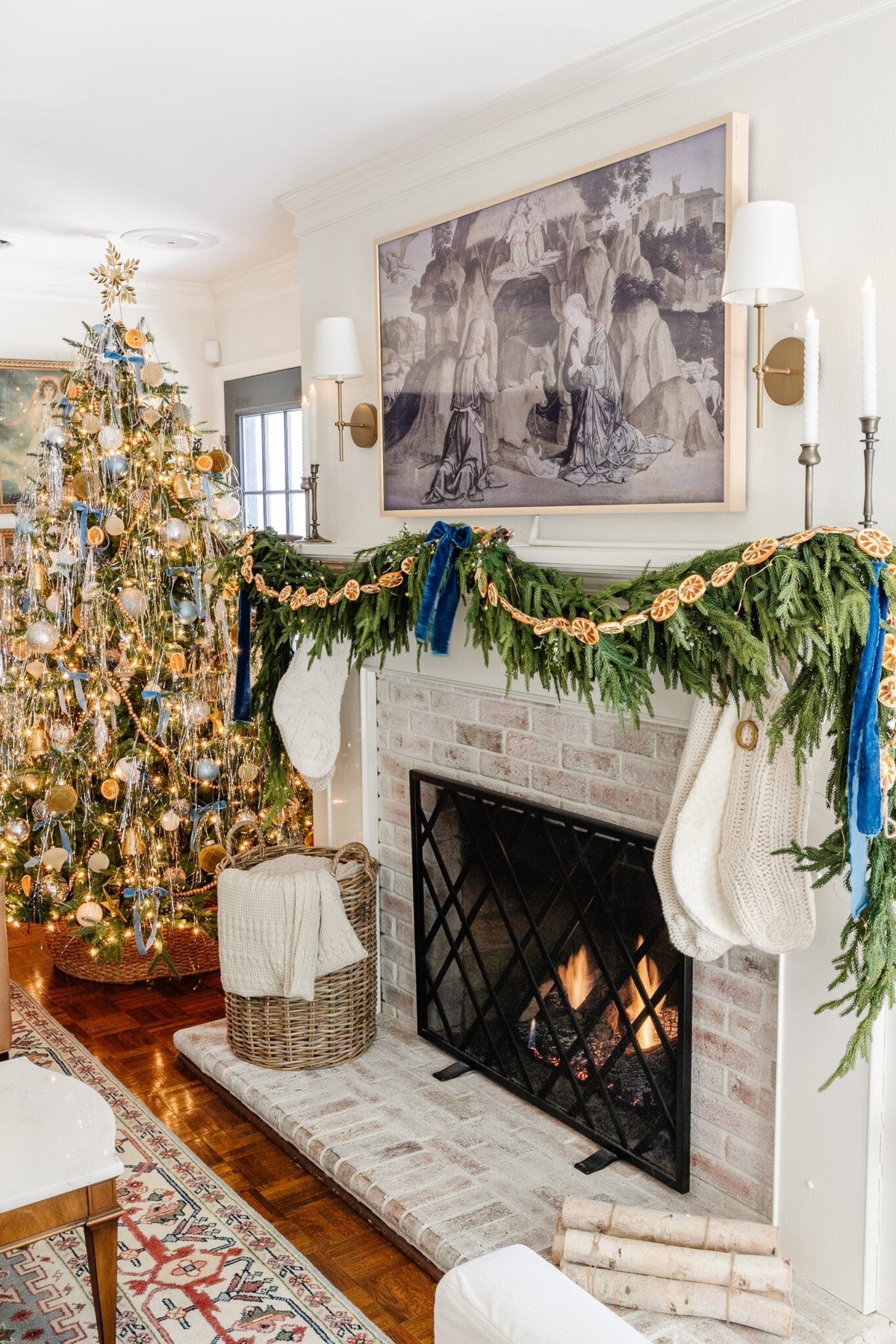 Christmas mantel decor using garland, dried oranges, and blue ribbon