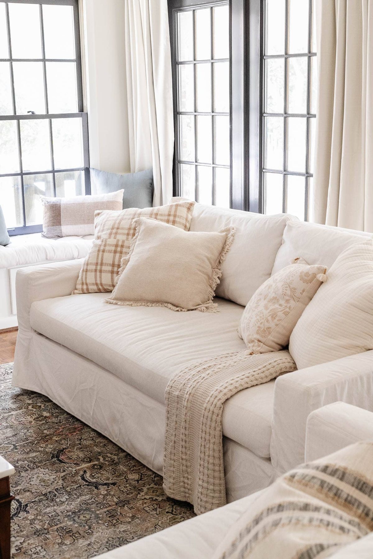 white Pottery Barn York sofa in a living room with black French doors and linen curtains