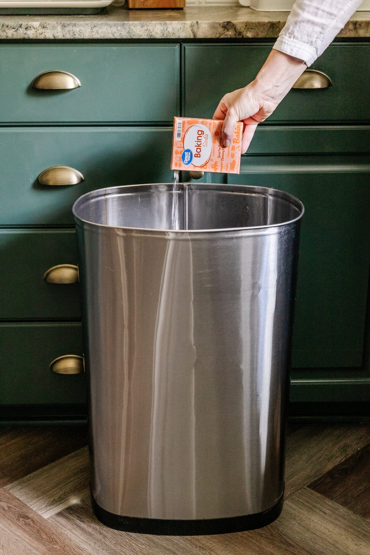 sprinkling baking soda in trash can