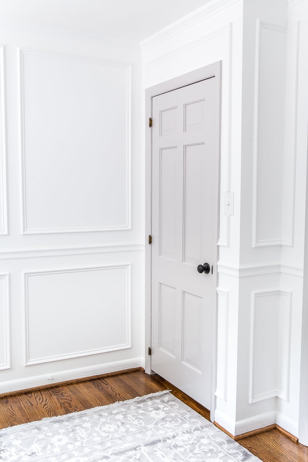 gray painted door with white walls and picture frame molding
