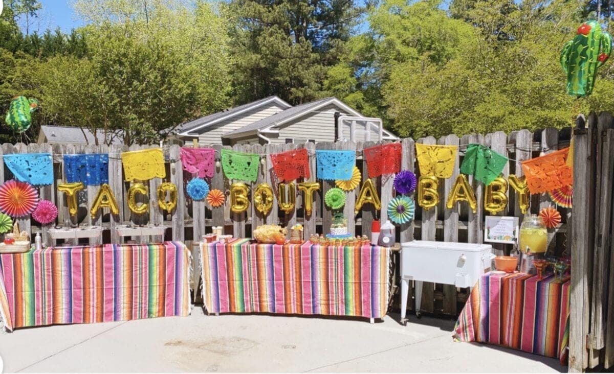 baby shower taco bar decorated with Mexican serape tablecloths and balloons