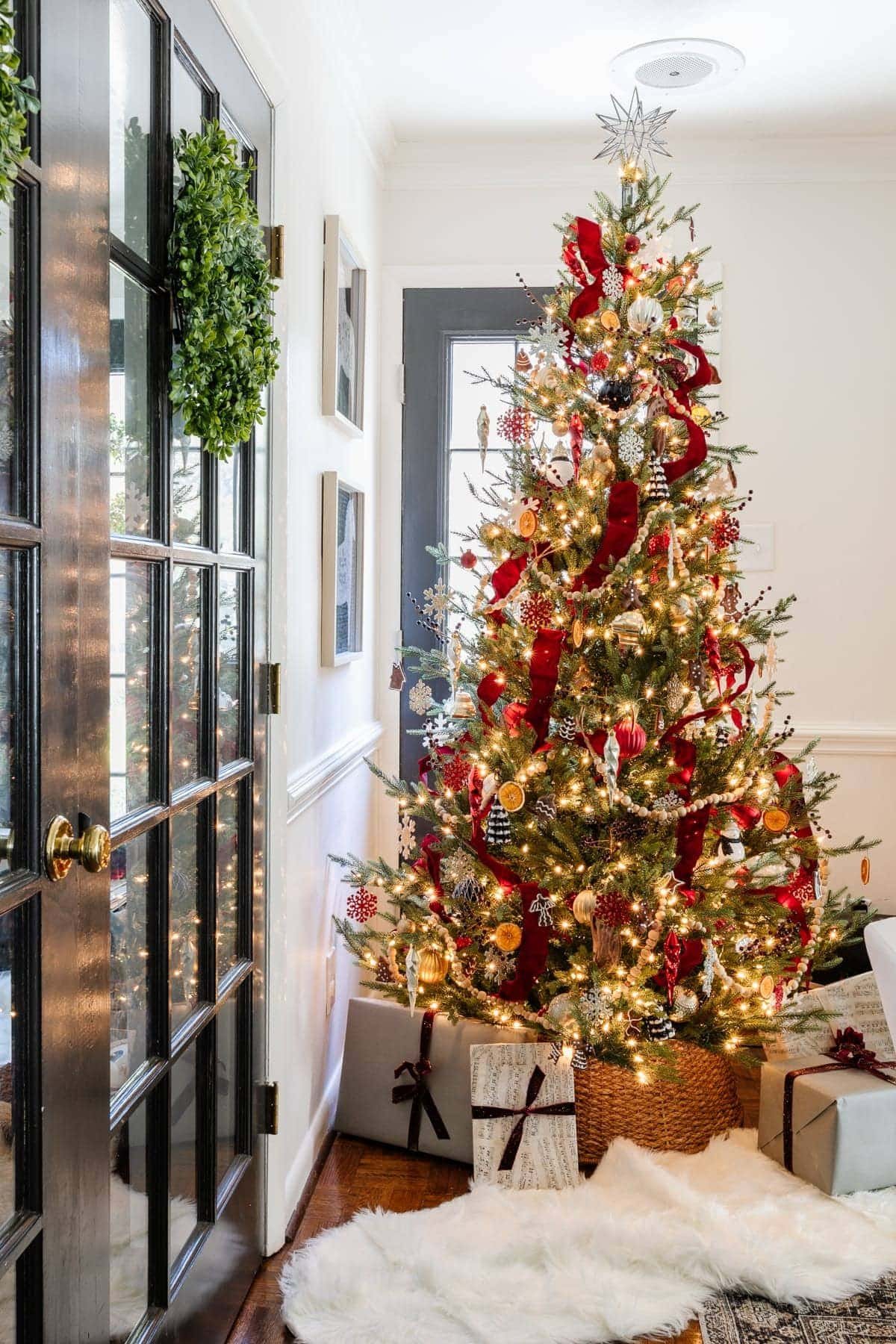 Christmas tree decorating with red tree ribbon