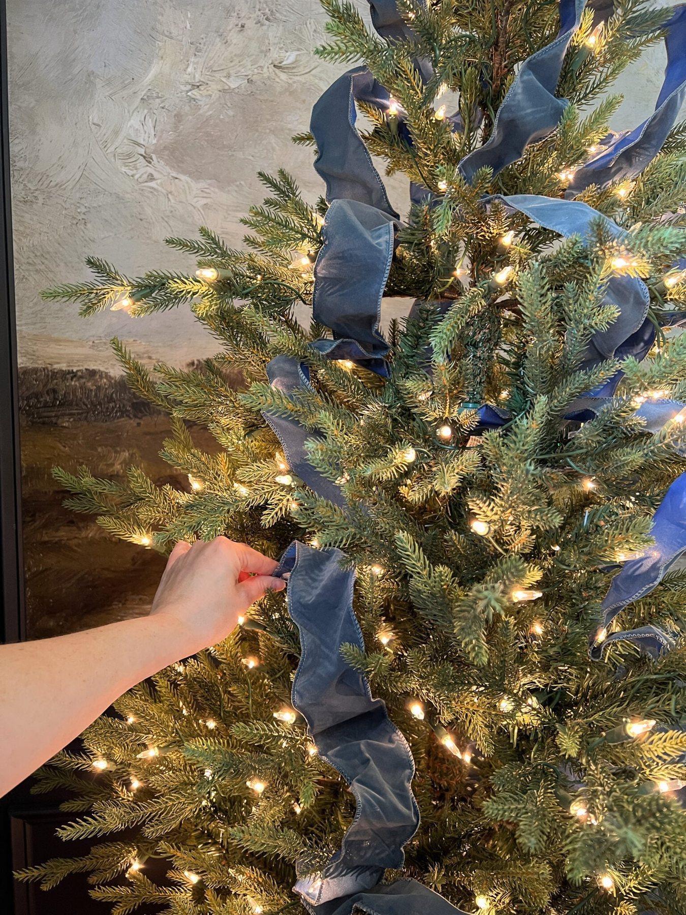 how to put on Christmas tree ribbon by tucking in pieces in a weaving pattern