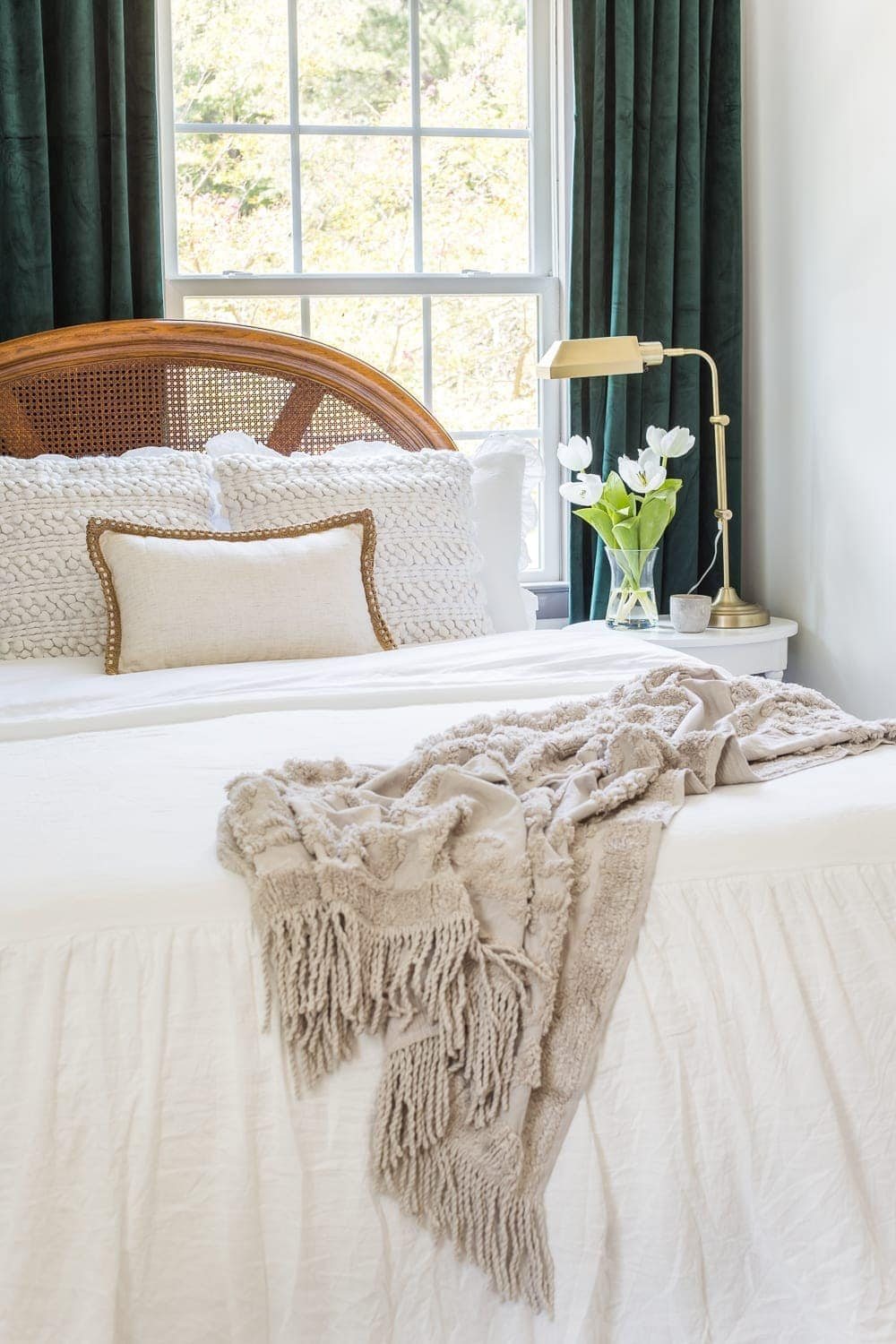 Guest bedroom makeover with linen skirted vintage style bedding and thrifted cane headboard
