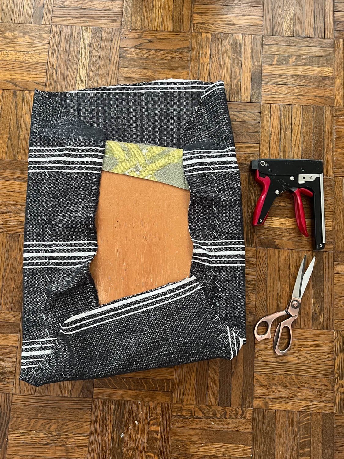 three sides of covering a dining chair seat with upholstery fabric and a staple gun