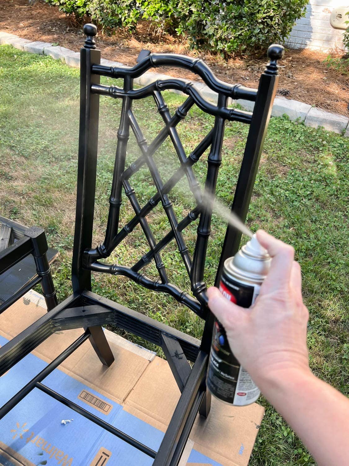 spray painting a bamboo chair with black paint