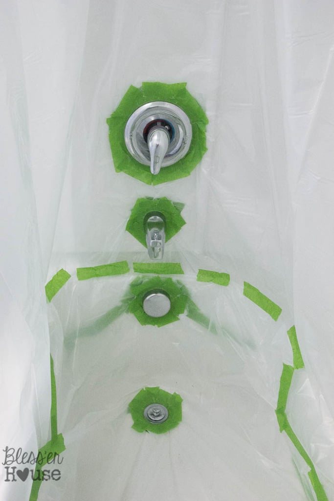 taped drop cloth to spray paint shower fixtures
