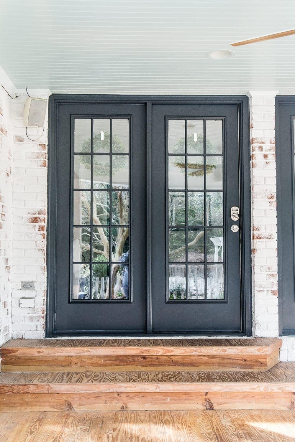 black French door on a back porch with haint blue porch ceiling