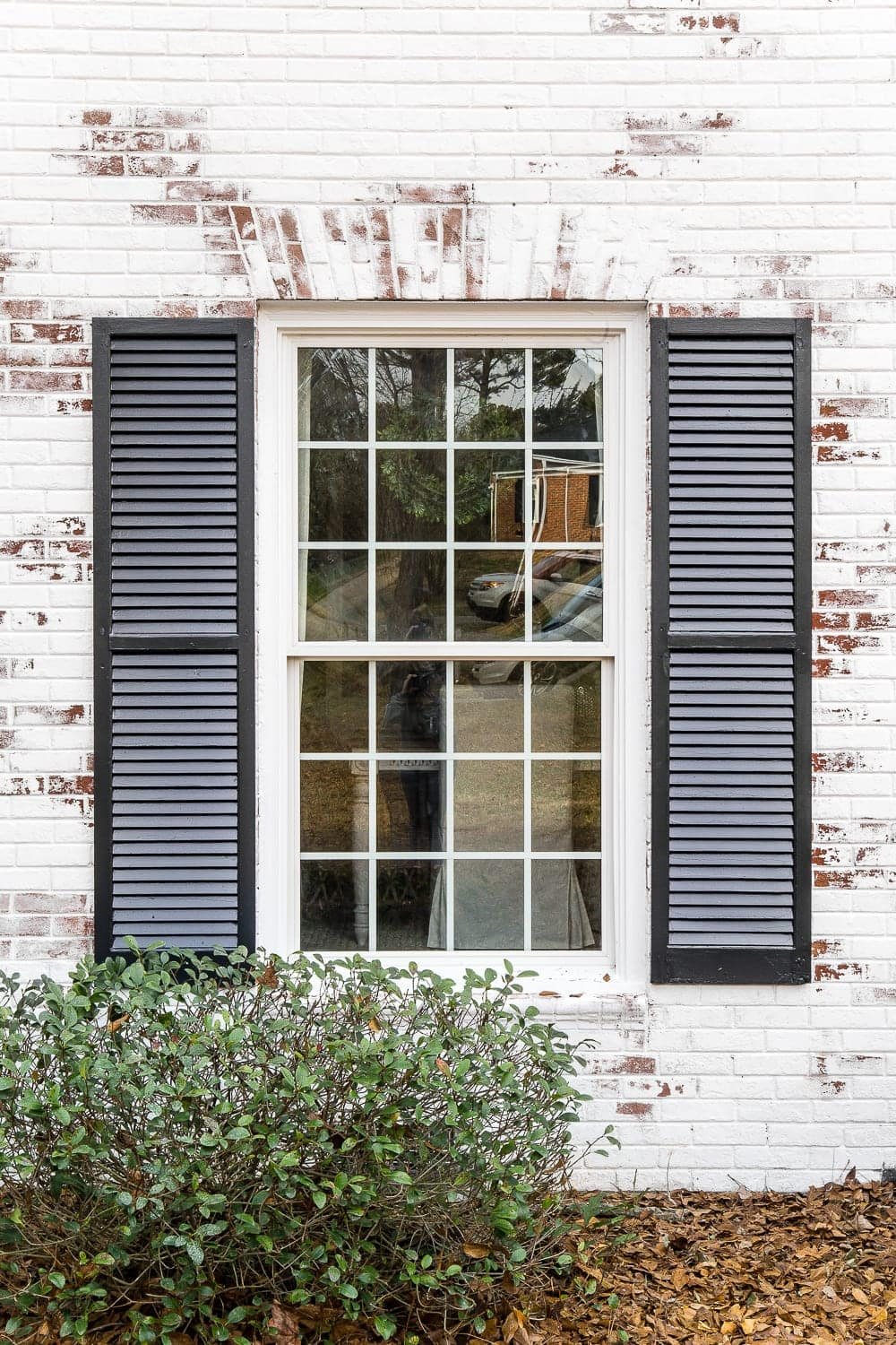 limewashed brick around window with black shutters