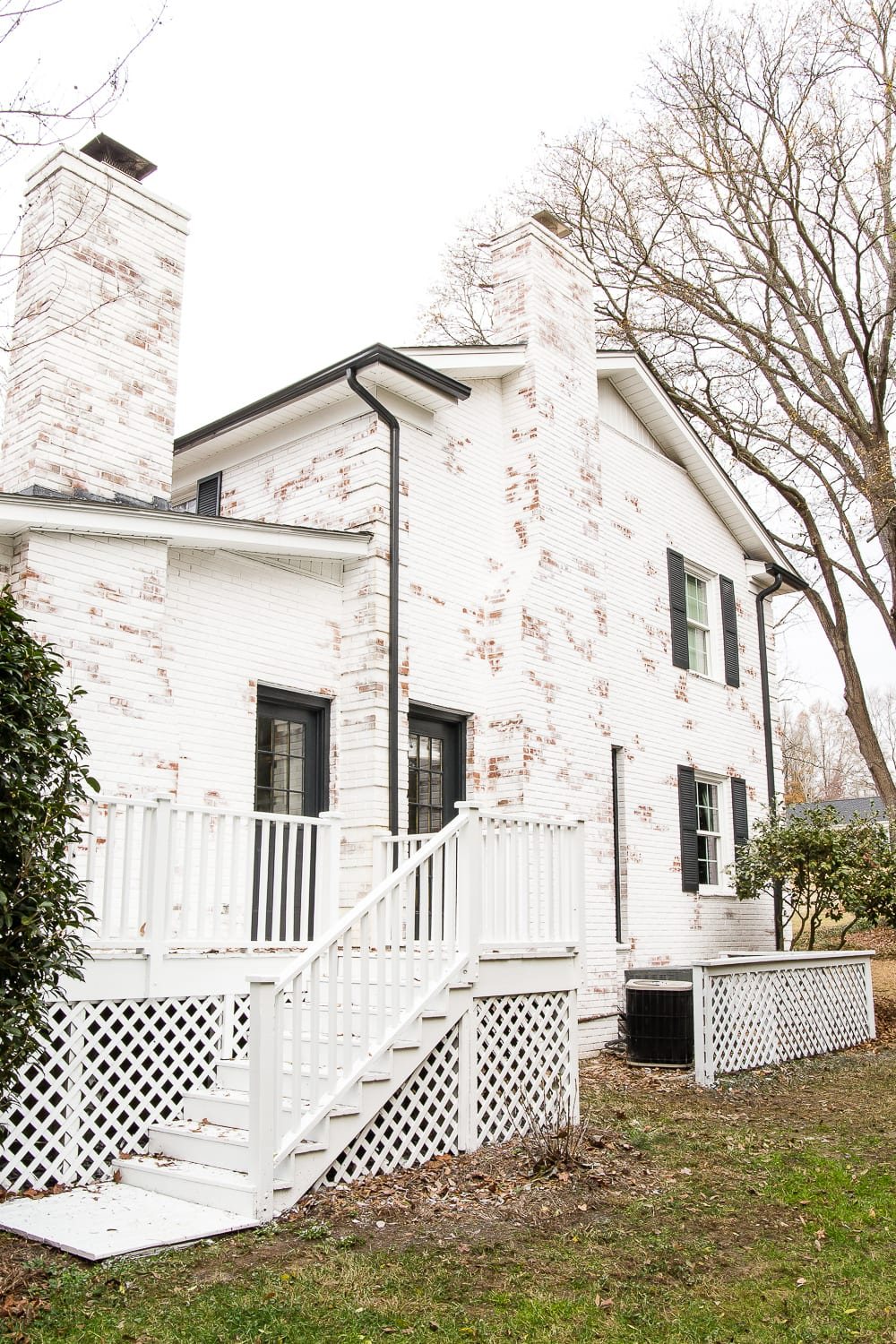 Romabio Bianco White limewash brick house makeover with black shutters