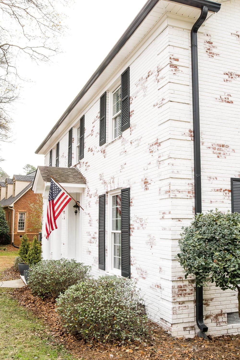 Romabio Bianco White brick with Behr Cracked Peppercorn Shutters and Gutters and Behr Ultra Pure White trim