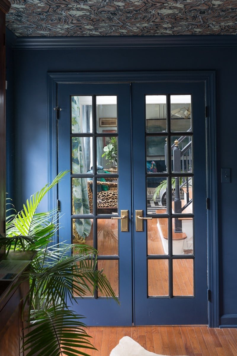 blue monochromatic french doors, trim, and walls with wallpapered ceiling