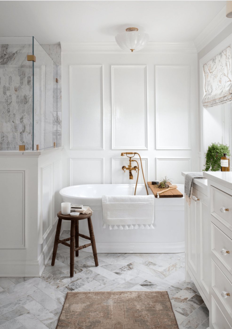 picture frame molding in a bathroom with soaking tub and herringbone tile