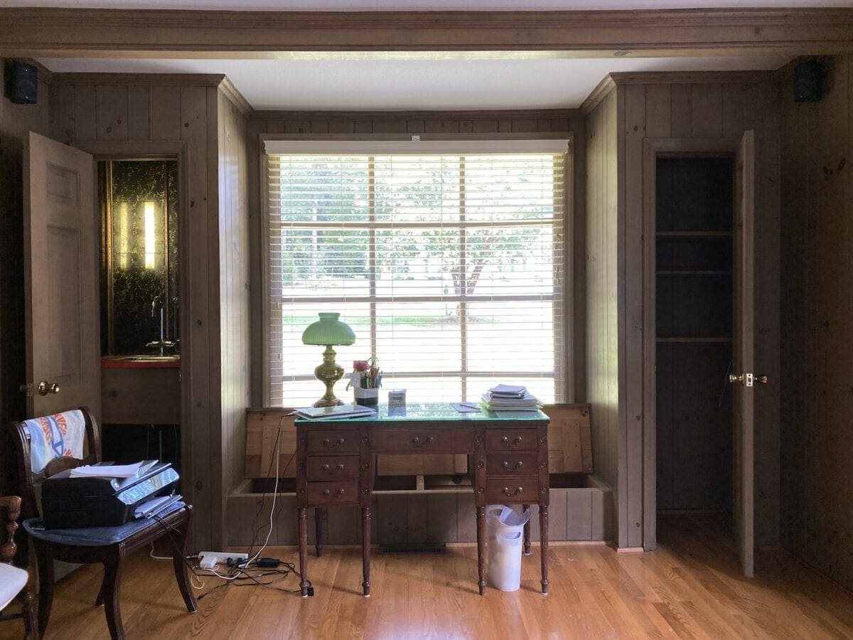 office in living room with wood paneling