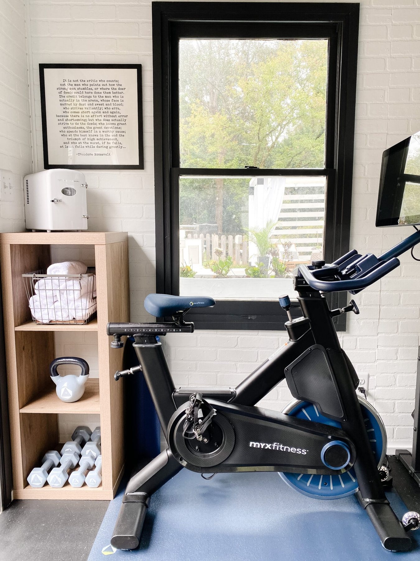 home gym shelves for storing mini fridge, hand weights, and gym towels