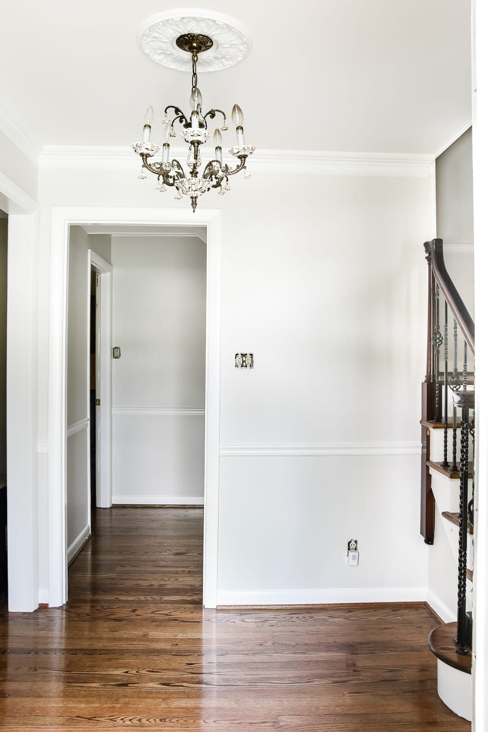 Neutral Painted Foyer Update | unigumushane.com - A drab, dated foyer and staircase get a bright, neutral facelift with high contrast details using Benjamin Moore colors Classic Gray and Wrought Iron.