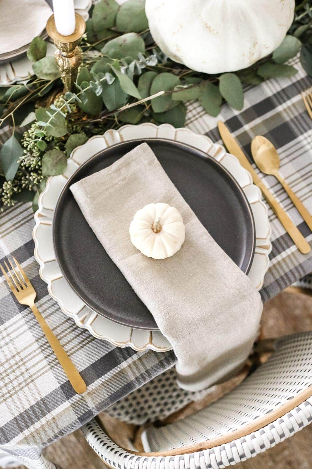 Neutral Low-Key Thanksgiving Tablescape | unigumushane.com - A neutral low-key Thanksgiving tablescape that is simple and inexpensive to recreate using plaid fabric, white pumpkins, eucalyptus, and brass.