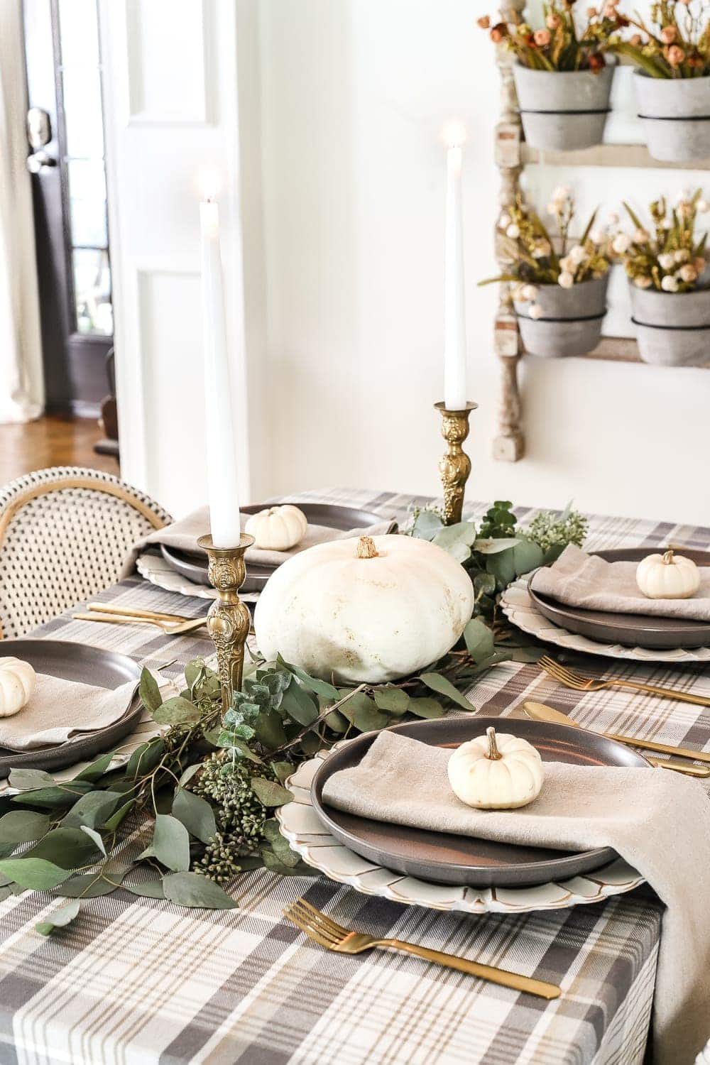 Neutral Low-Key Thanksgiving Tablescape | unigumushane.com - A neutral low-key Thanksgiving tablescape that is simple and inexpensive to recreate using plaid fabric, white pumpkins, eucalyptus, and brass.