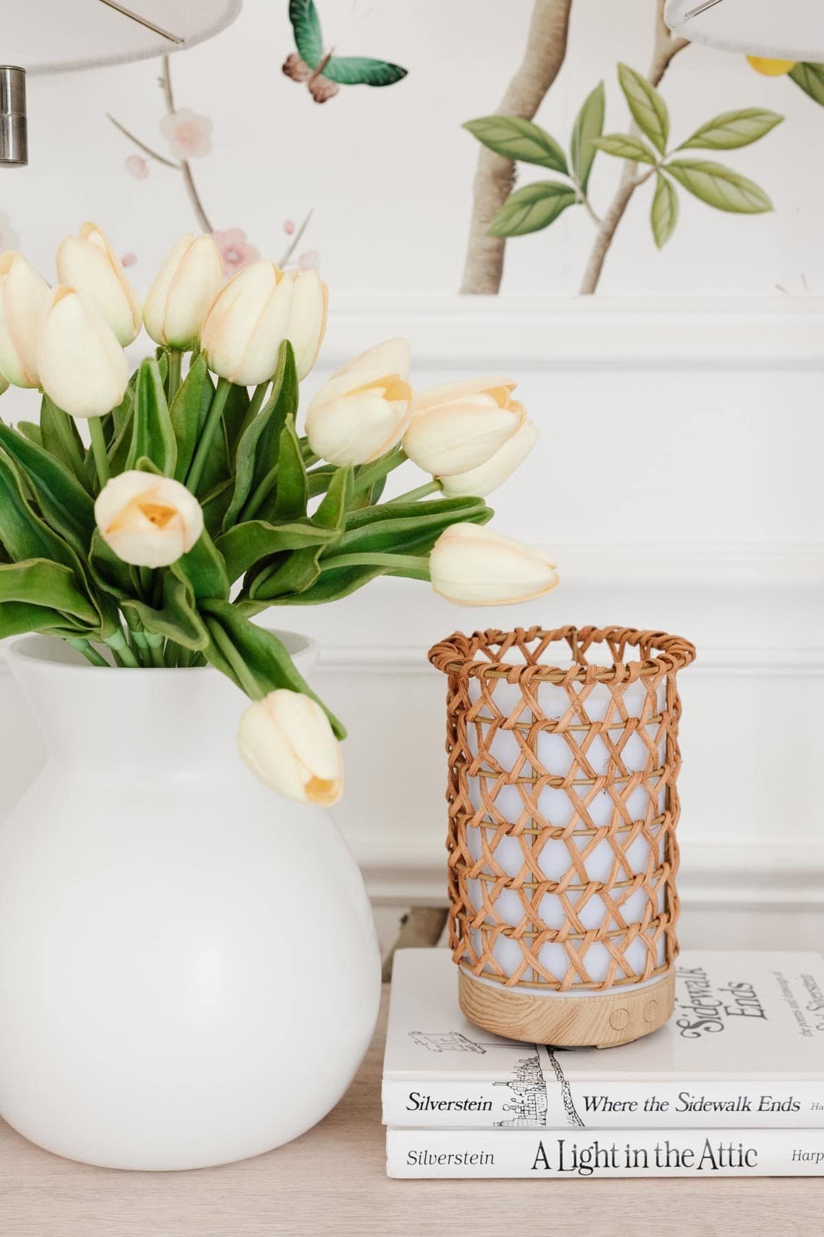 white vase of flowers with rattan diffuser