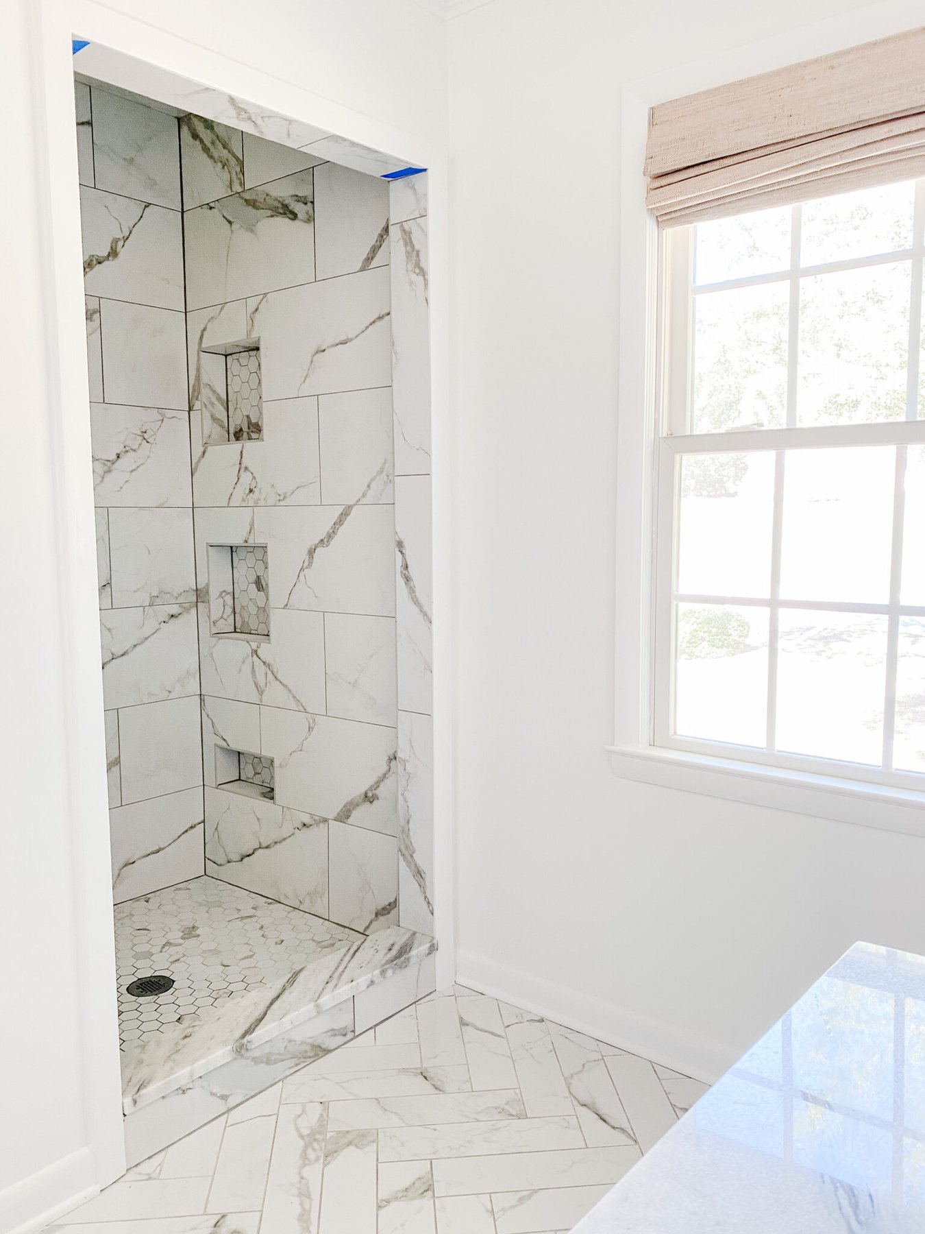 marble look porcelain tile shower with shower niches