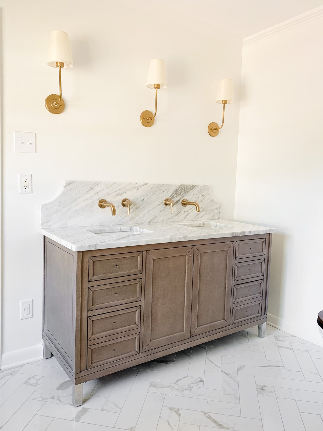 wood bathroom vanity with scalloped marble backsplash