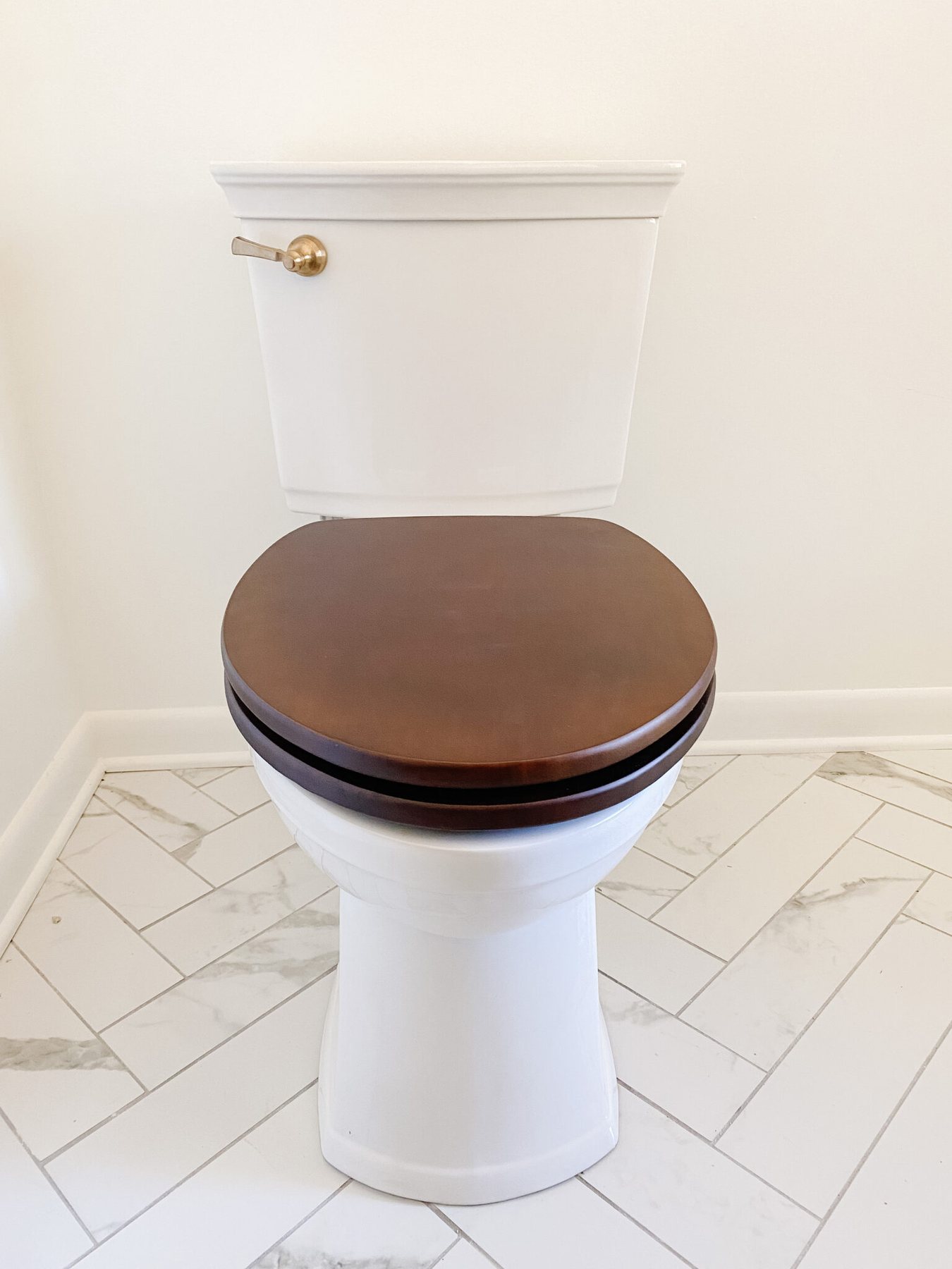 toilet with wooden toilet seat and gold flush lever