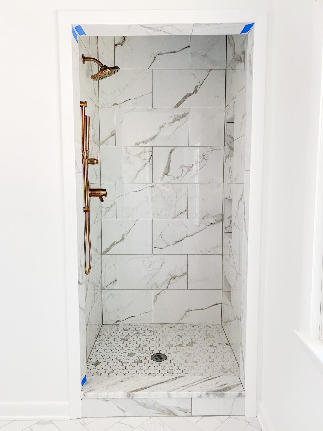 faux marble porcelain tile shower with gold shower faucets
