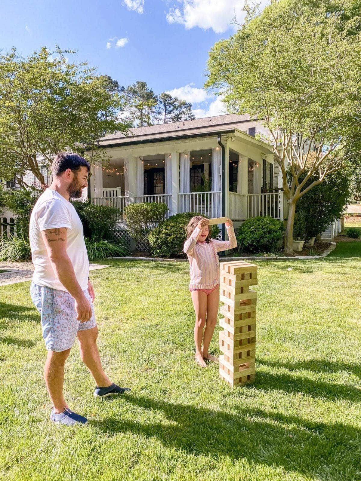 father and daughter playing backyard Giant Jenga yard game