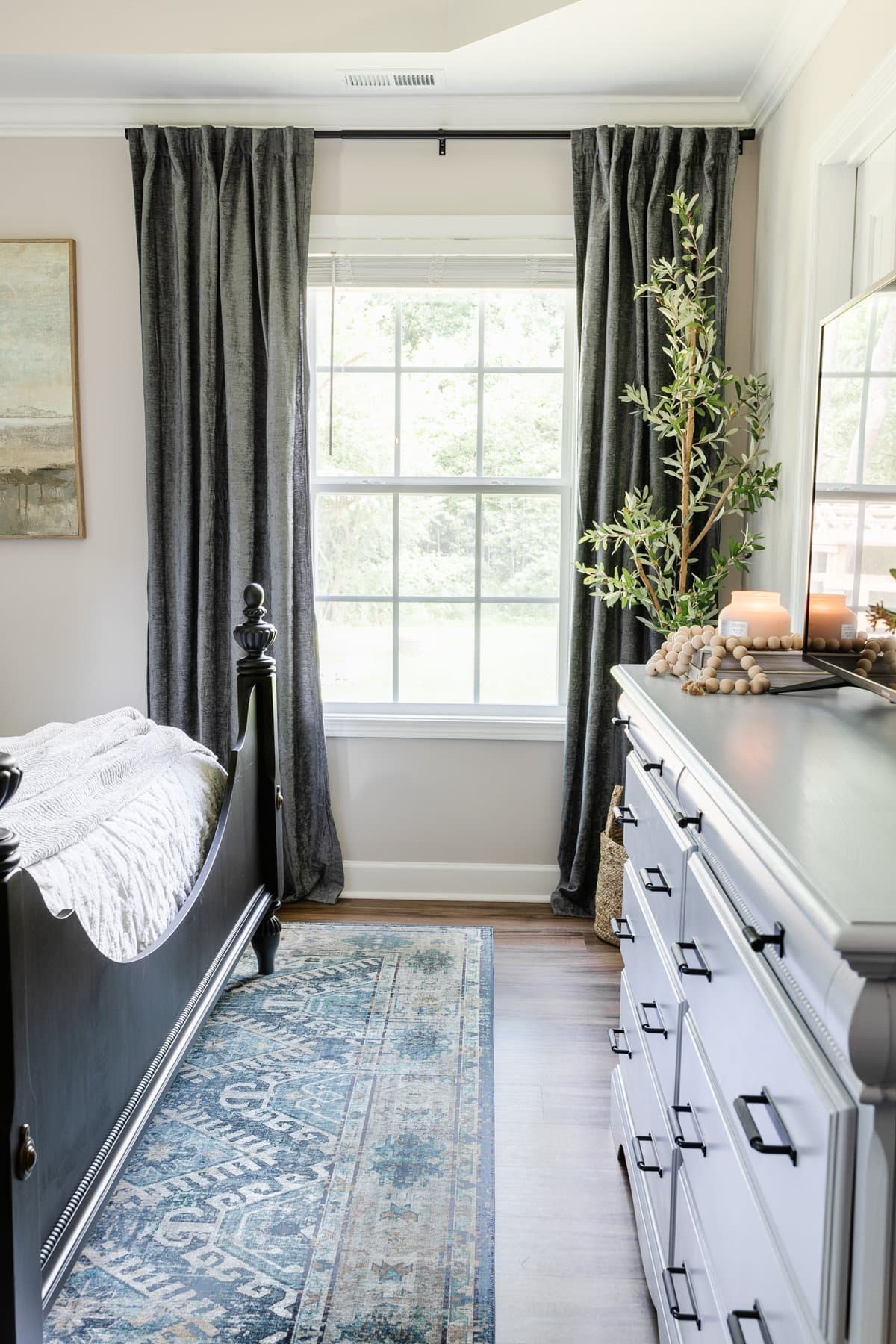 curtain panels hung high and wide in a small bedroom to make it look bigger