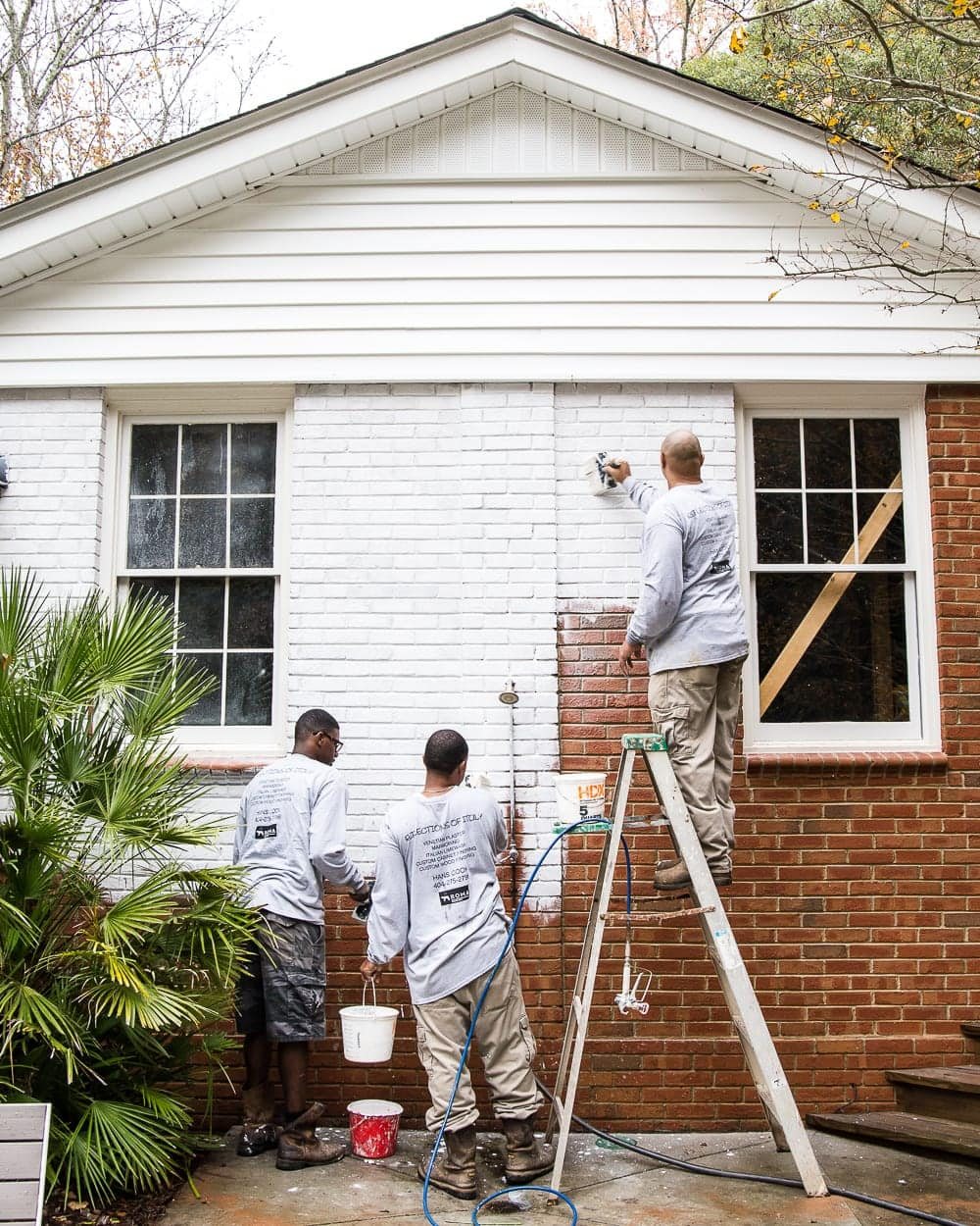 hand brushing Romabio Bianco White limewash paint on brick exterior