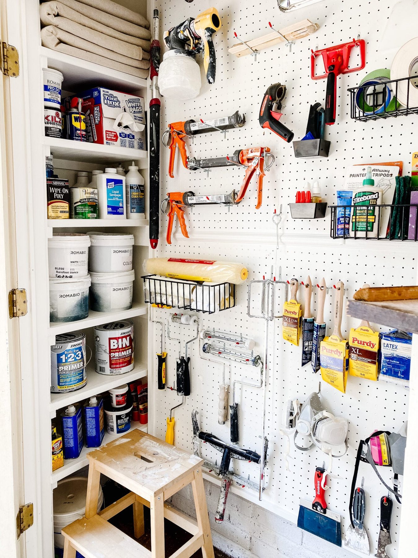 organizing paint supplies with DIY shelves and pegboard hooks and baskets