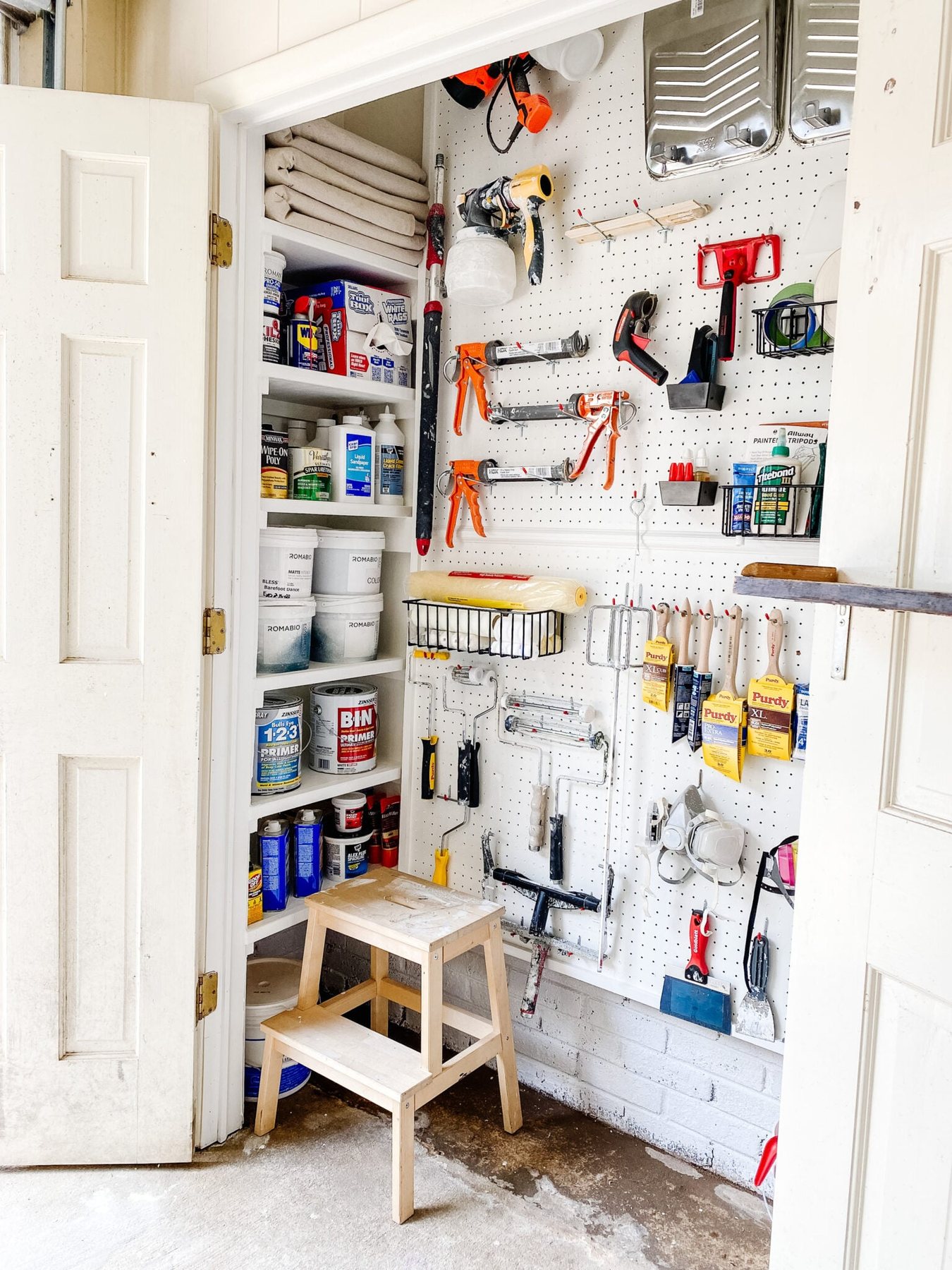 DIY shelves for paint storage and organized paint supplies with pegboard hooks