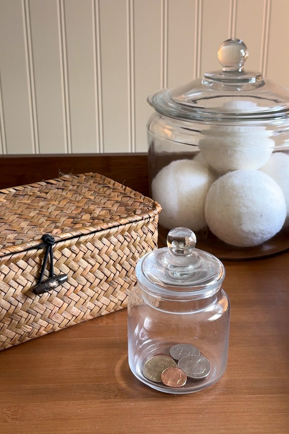 small laundry room organization - basket and apothecary jars for loose change, lost socks, and wool dryer balls