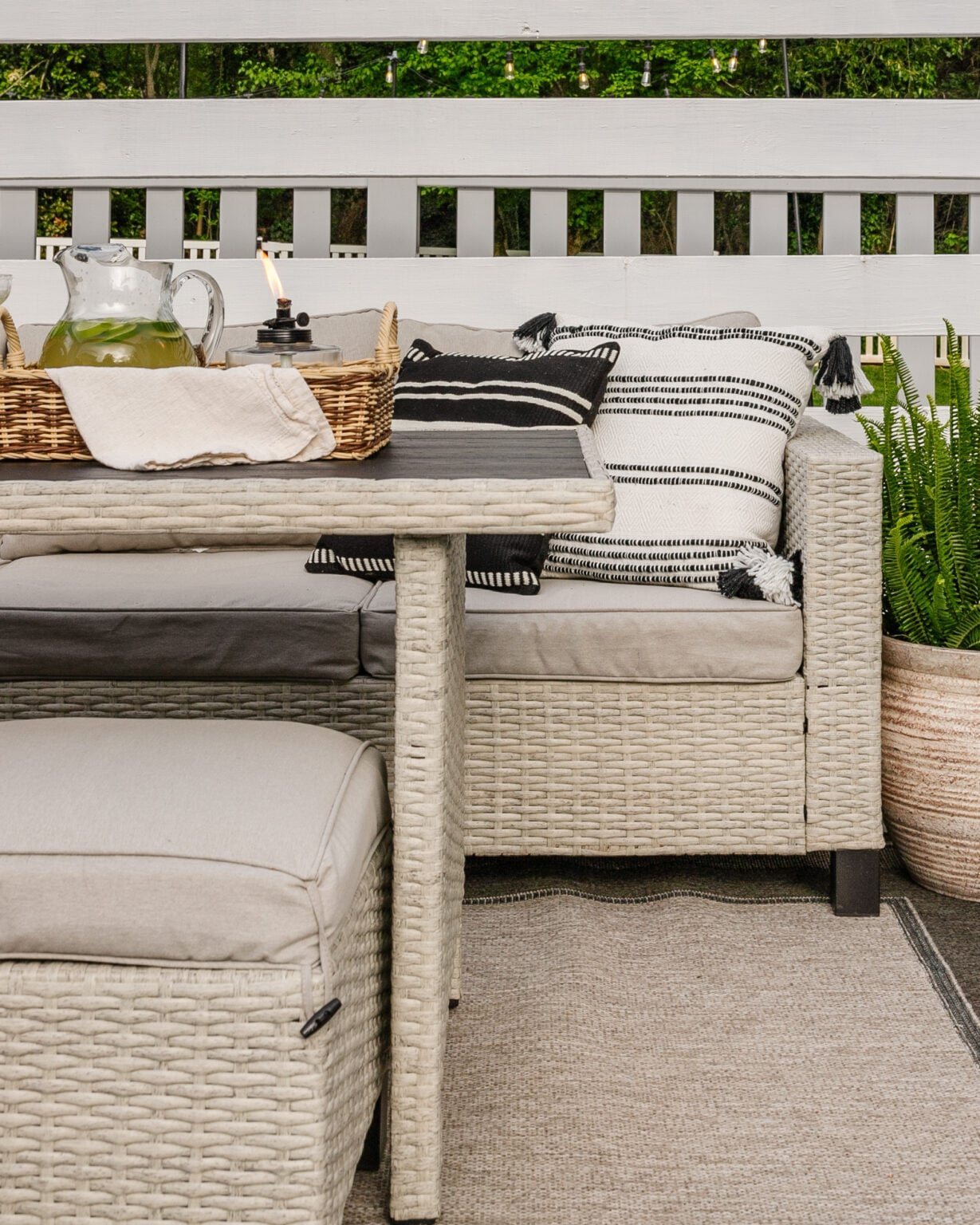 wicker patio dining set under a backyard pergola