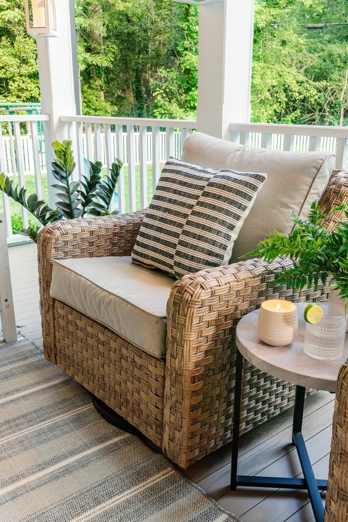 wicker swivel chairs on a back porch with side table