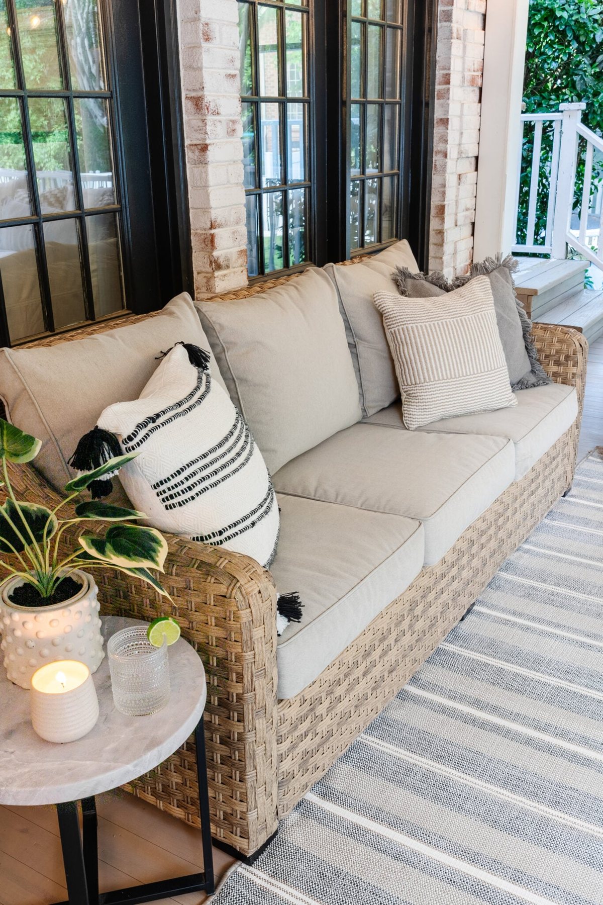 patio sofa on a back porch with neutral outdoor pillows