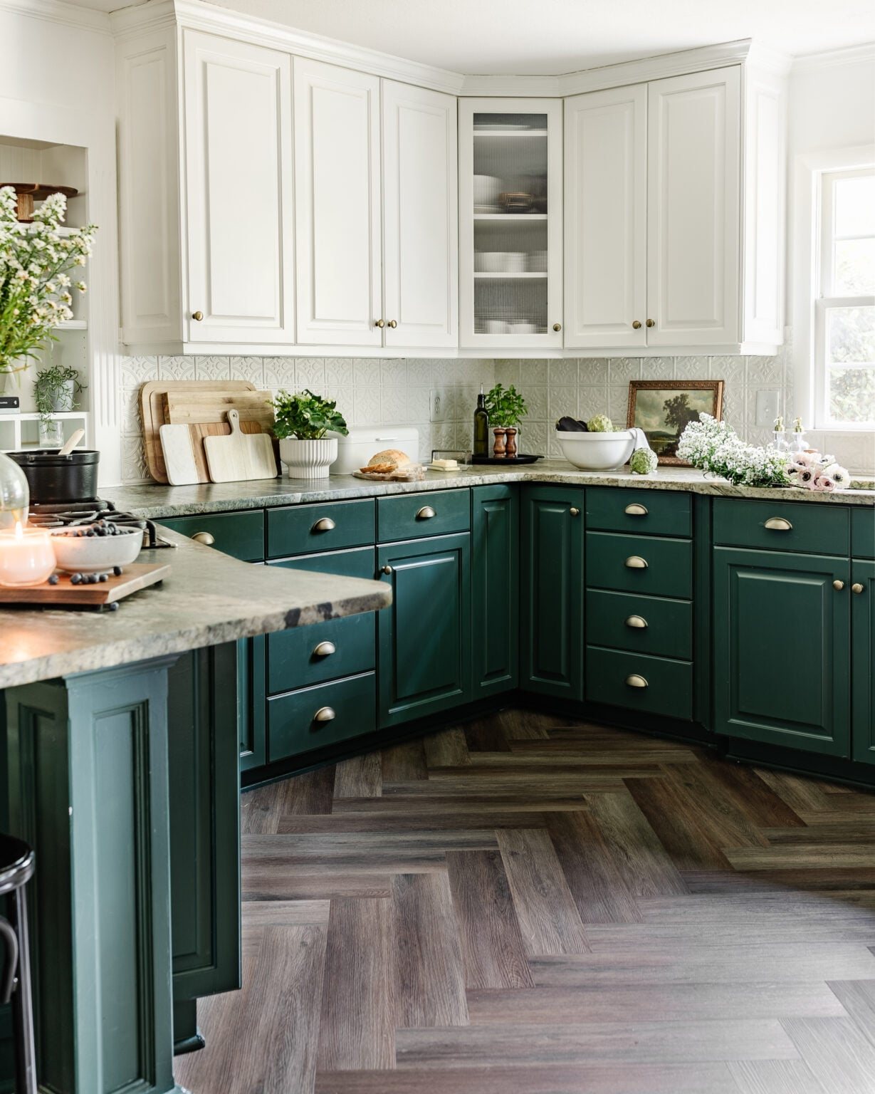 cottagecore style kitchen facelift with herringbone floors, green and white cabinets, leathered granite countertops, and pressed tin backsplash
