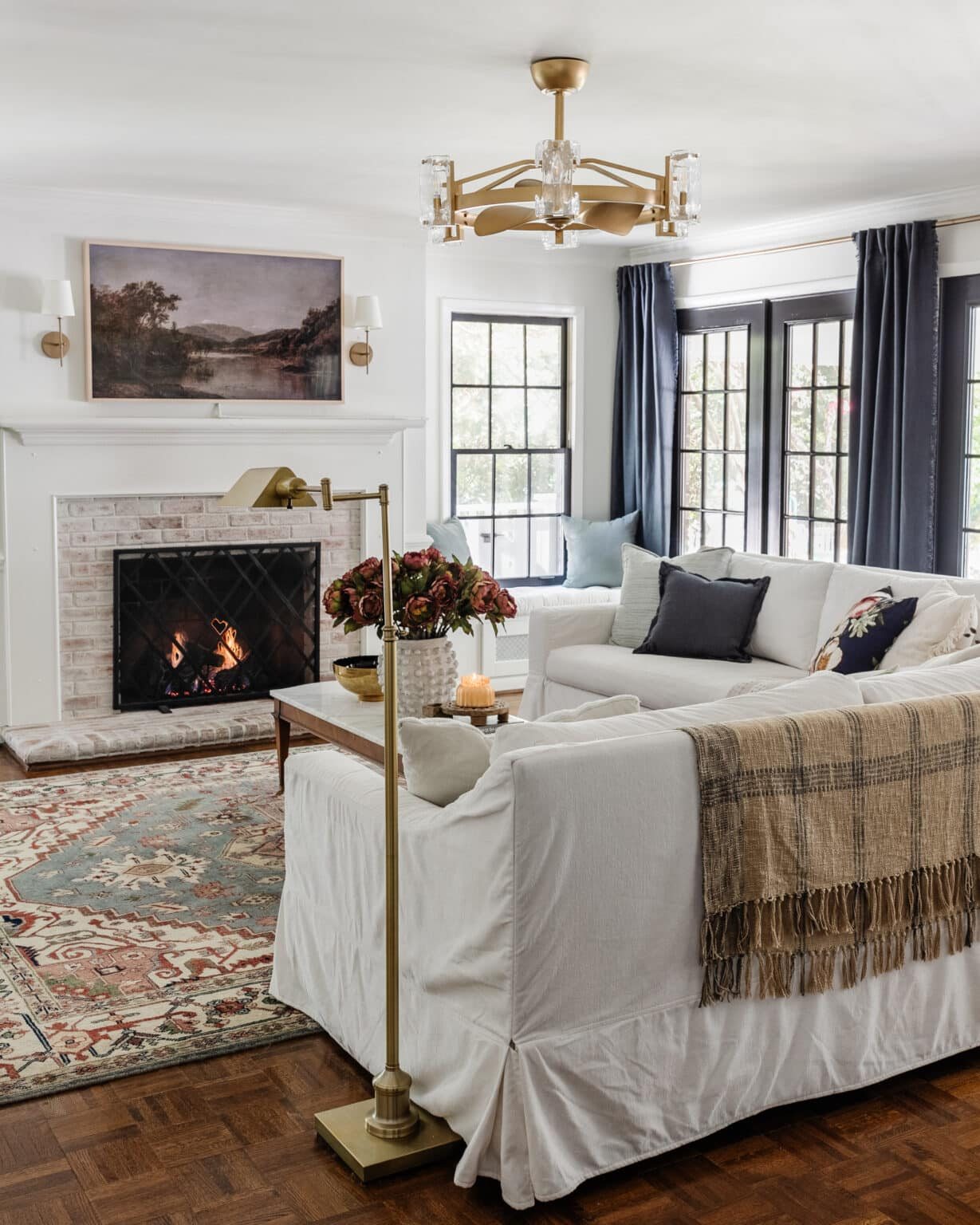 modern traditional living room with brass floor lamp and plaid blanket on back of couch