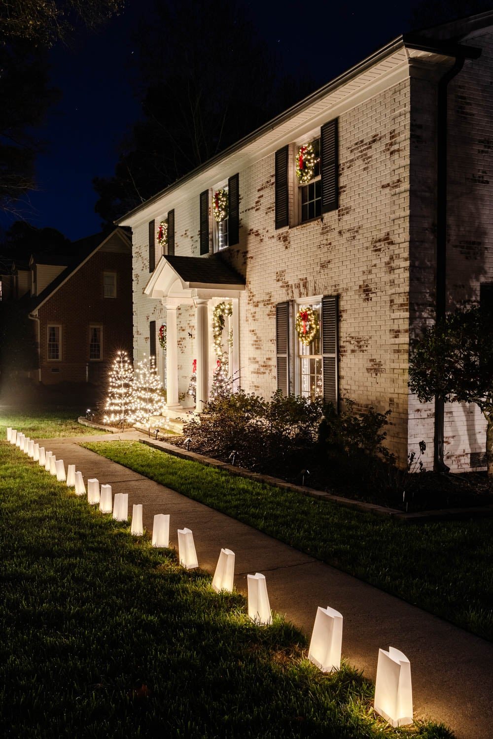 white limewash brick colonial with Christmas decor and outdoor Christmas lights