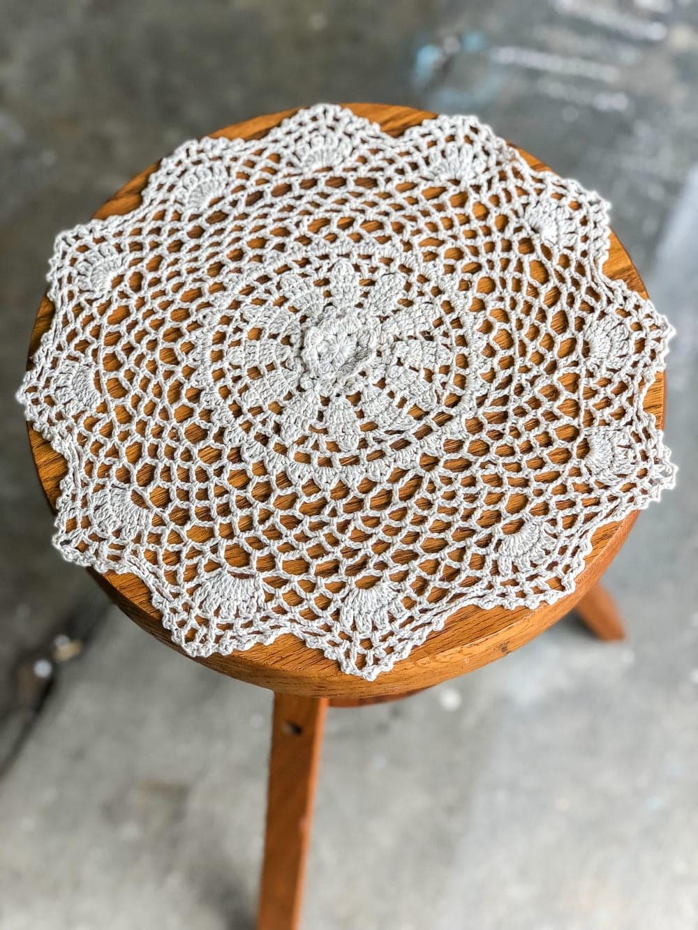 A global designer-inspired DIY plant stand made from a thrifted piano stool using just spray paint and a doily for a quick and easy makeover. #plantstand #pianostool #globaldecor #spraypaint #thriftstoreflips #thrifting #diyhomedecor #thriftedhomedecor