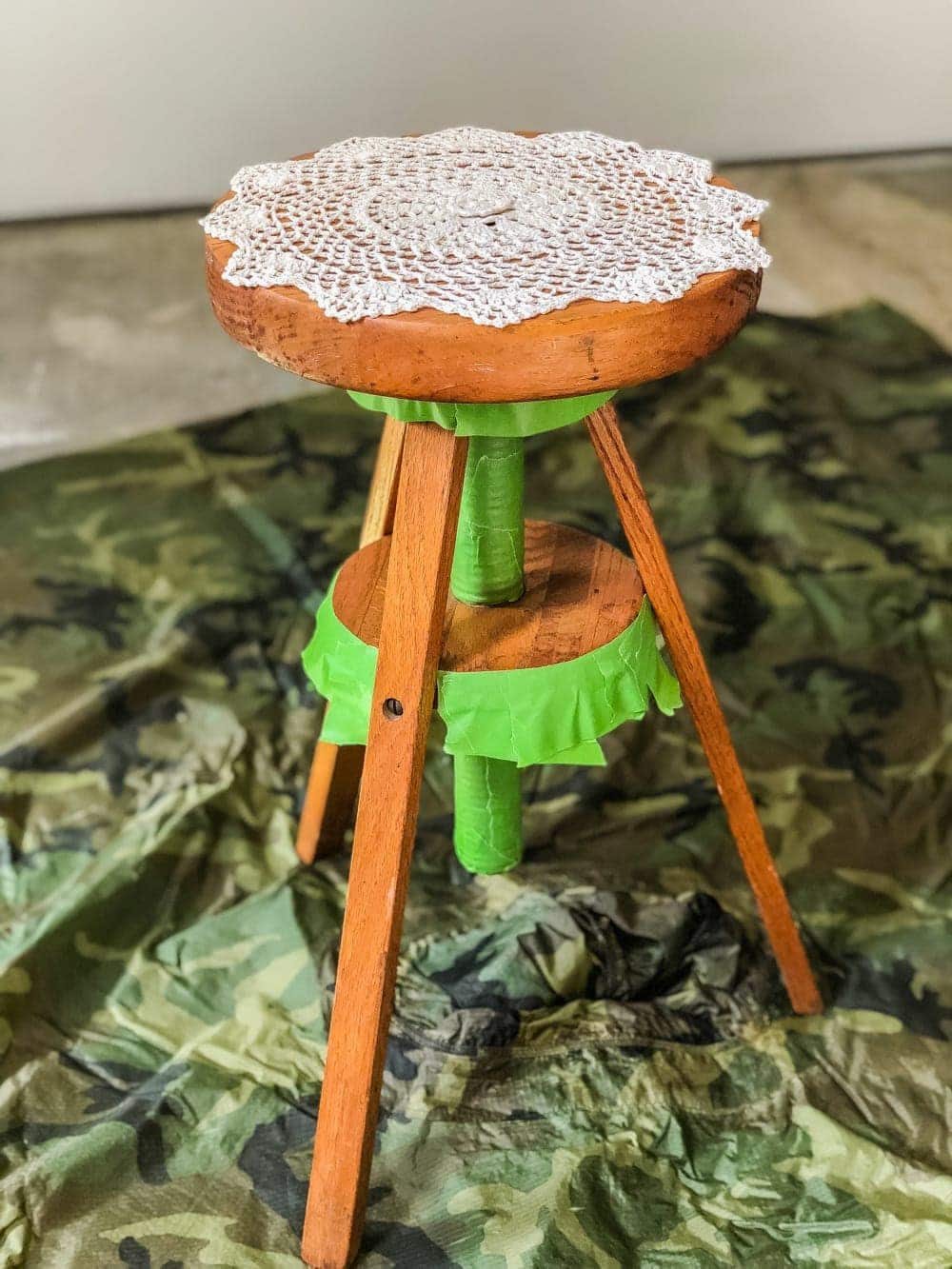 A global designer-inspired DIY plant stand made from a thrifted piano stool using just spray paint and a doily for a quick and easy makeover. #plantstand #pianostool #globaldecor #spraypaint #thriftstoreflips #thrifting #diyhomedecor #thriftedhomedecor