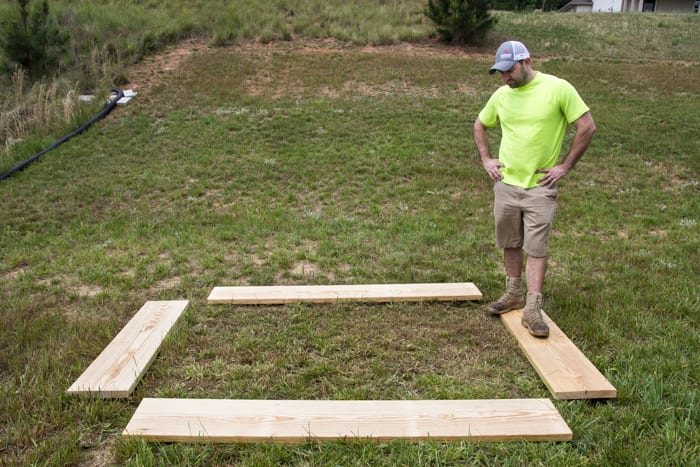 pine boards in a backyard laid out for building a raised bed vegetable garden frame