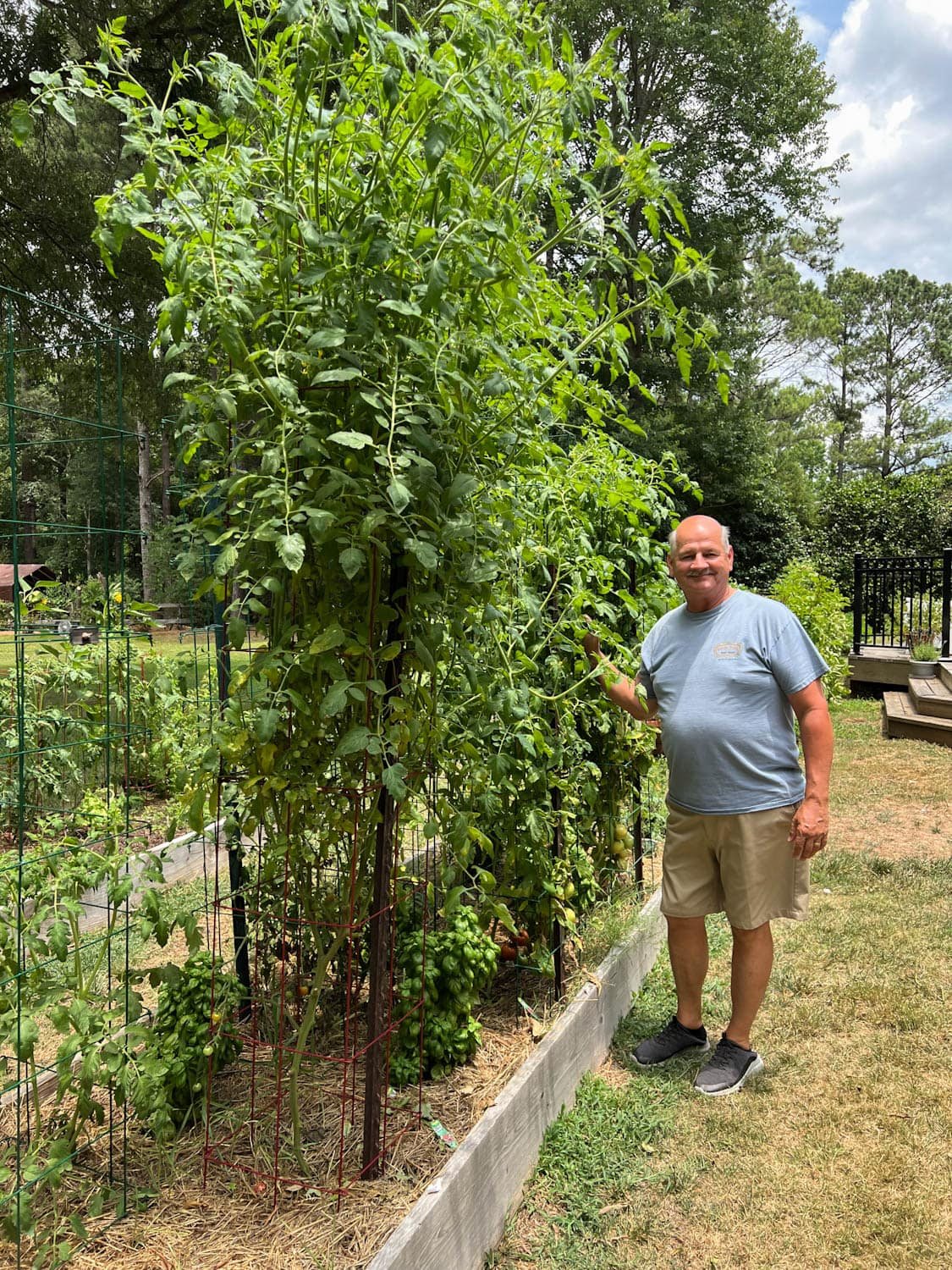 man standing next to a a 12 feet tall raised bed vegetable garden