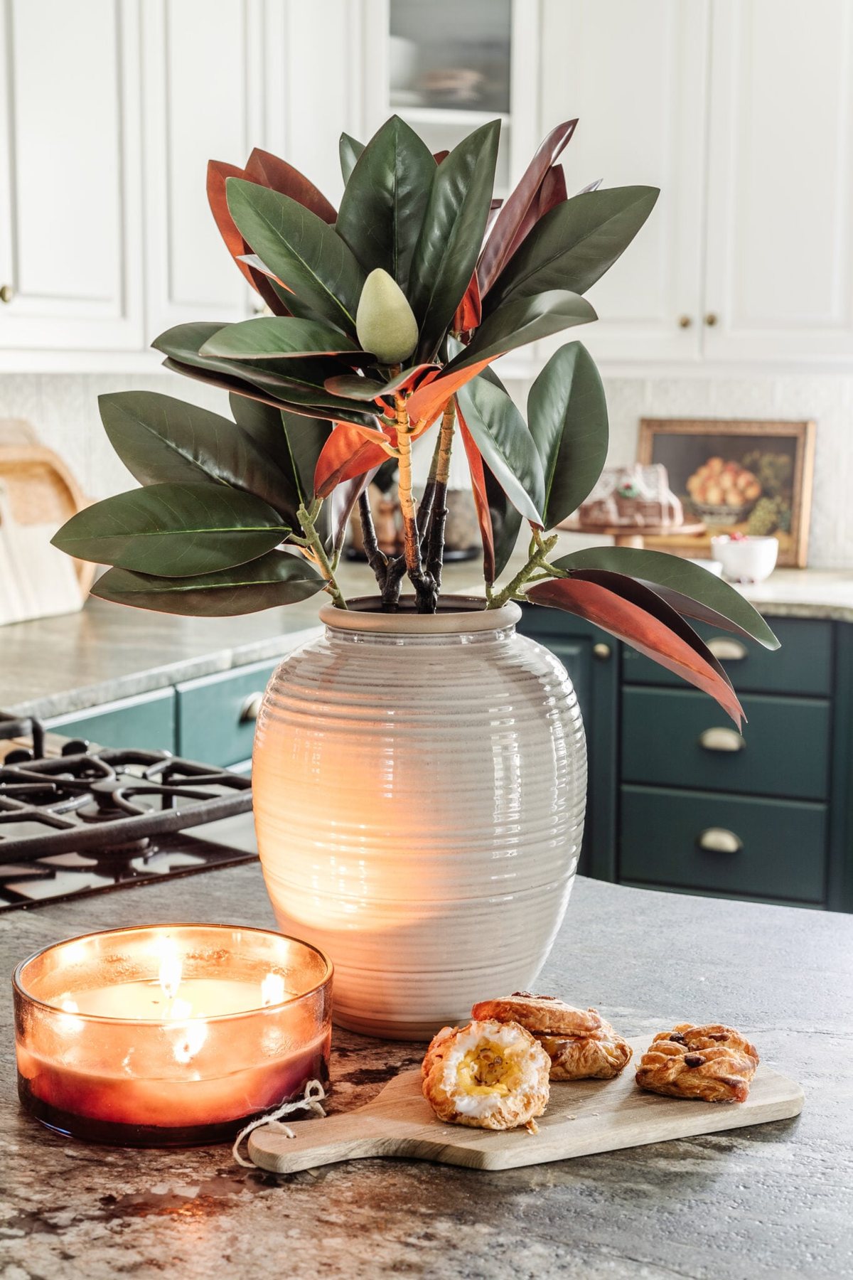 stem of magnolia stems in a vase on a kitchen countertop decorated for Christmas