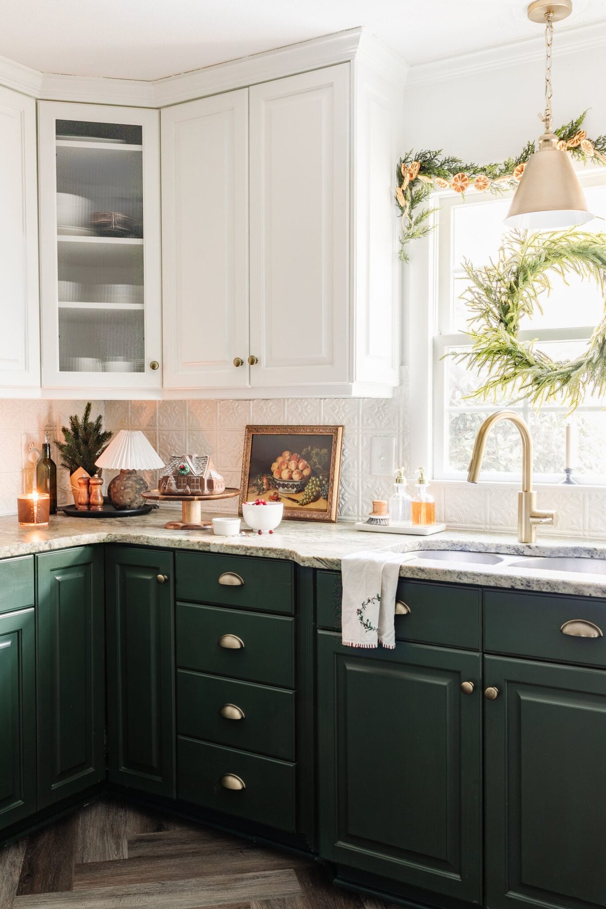 Christmas decor on a kitchen countertop and wreath and garland on window